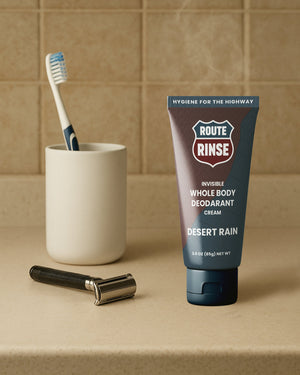 Tube of Route Rinse deodorant cream on a bathroom counter with a toothbrush and razor.